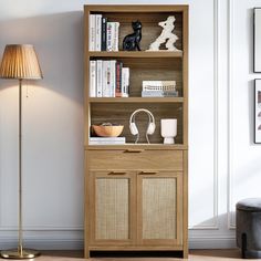 a wooden bookcase with books and headphones on it in front of a lamp