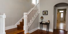 an empty entryway with stairs leading to the second floor and another room in the background