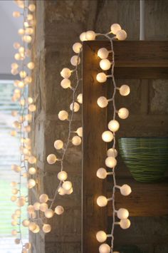 a string of lights hanging from the side of a wall in front of a window