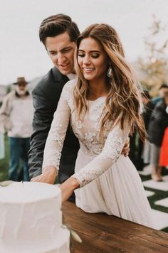 a newly married couple cutting their wedding cake