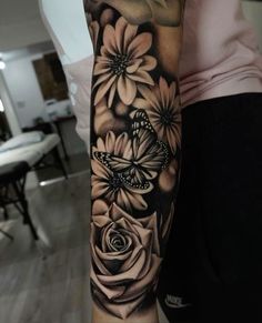 a woman's arm with flowers and butterflies on it