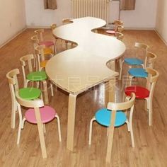 an empty room with many chairs and tables in the center, all painted different colors