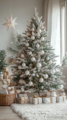 a white christmas tree with presents under it