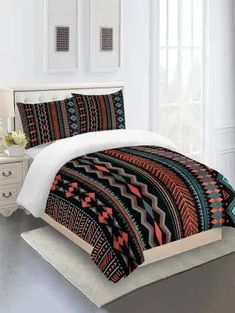 a bed with a colorful comforter and pillows