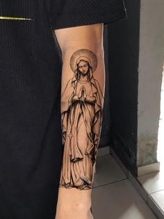 a person with a tattoo on their arm and the image of jesus holding a cross