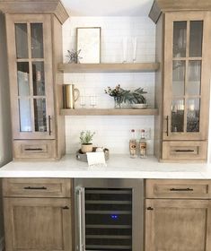 a kitchen with built in wine cooler and cabinets on the wall, along with an oven