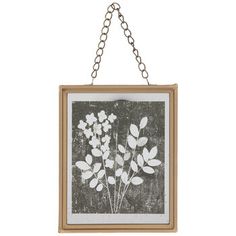 a painting hanging from a chain on the wall with leaves and flowers painted on it