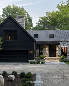 a large black house with stone walls and windows