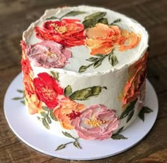 a white cake with red and orange flowers on it