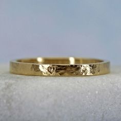 This personalized gold stacking ring has a rustic distressed finish that gives it a gentle timeworn vibe. The distressed finish gives the ring a subtle shine. Your inscription can go on the outside or the inside of this sweet little ring. Details Made from solid 14k yellow gold. 2mm wide and about 1.2mm thick. Rustic hammered finish Price includes an inscription of up to 14 characters.Available are uppercase letters A-Z, numbers 0-9, &, . , -, and a little heart symbol Important! The ring will b 14k Gold Hammered Stackable Promise Rings, Gold Hammered Stackable Rings For Promise, Dainty Hammered Rings As Gift, Dainty Hammered Rings For Gifts, Hammered 14k Gold Stackable Wedding Rings, Hand Forged Dainty Rings For Anniversary, Gold Hammered Stackable Rings For Anniversary, Anniversary Yellow Gold Hammered Stackable Rings, 14k Gold Hammered Stackable Wedding Rings