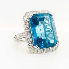 This 26 carat ocean blue topaz is an amazing site to see! Her emerald cut and her royal blue color is absolutely gorgeous! You will not believe the size and brilliance of this genuine gemstone! There is a edge of diamonds on all the sides and there is 1.00 carat total weight of diamonds to sparkle and shine next to the ocean blue topaz. This is a statement ring like no other! This ring is made to order and takes 10 to 12 weeks to make. We can make it in the ring size you want and because it is c Blue Octagon Rings With Diamond Accents, Luxury Octagon Topaz Ring As A Gift, Emerald Cut Topaz Ring With Diamond And Gemstone Accents, Luxury Octagon Topaz Ring Gift, Luxury Octagon Topaz Ring, Luxury Emerald Cut Blue Topaz Ring, Blue Emerald-cut Topaz Ring With Diamond Accents, Blue Topaz Ring With Emerald Diamond Cut, Emerald-cut Blue Topaz Ring With Diamond Cut