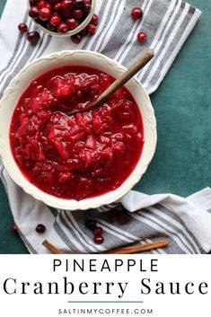 cranberry sauce in a white bowl on top of a striped towel with cinnamon sticks