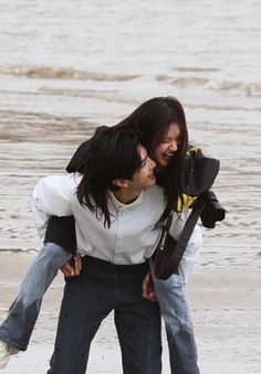 a man carrying a woman on his back at the beach