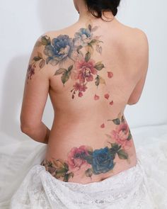 the back of a woman's body with flowers on her chest and lower back