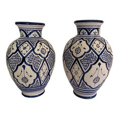 two blue and white vases sitting next to each other