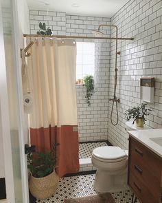 a white toilet sitting next to a bathroom sink under a shower curtain in a bathroom