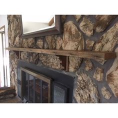 a stone fireplace with a mirror above it