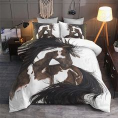 a bed with a white and brown horse comforter on top of it next to a night stand