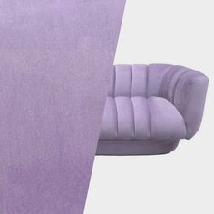 a purple couch sitting in front of a white wall with the corner cut out to show it's fabric