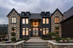 a large gray house with stone steps leading up to the front door and entry way