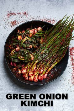 green onion kimchi in a skillet with red pepper sprinkles on the side