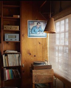 an old record player sits in front of a wooden bookcase