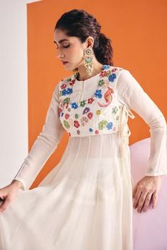 Ivory sleeveless side tie-up bib with all over multi toned floral patchwork, moti, cutdana and bead embellishments. Paired with a subtle ruffled hem solid kalidar anarkali with moti mebellishments on the crew neckline and a matching flared palazzo pant. - Aza Fashions Off White Salwar Kameez With Cutdana And Long Sleeves, White Anarkali Blouse For Eid, Eid Anarkali Style White Blouse, Transitional Multicolor Long Sleeve Anarkali Set, Multicolor Long Sleeve Salwar Kameez With Cutdana, Long Sleeve Choli With Chikankari Embroidery, White Bohemian Anarkali Set With Long Sleeves, Off White Long Sleeve Sets For Navratri, Festive Choli With Chikankari Embroidery And Long Sleeves