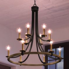 A beautiful UEX2381 Lux Industrial Chandelier hangs in a room. Foyer Chandelier Black, Front Entry Light Fixture, 2 Story Foyer Chandelier, Black And Brass Chandelier, Entry Lights, Layered Candles, Entryway Light Fixtures, Modern Farmhouse Chandelier, Entryway Chandelier