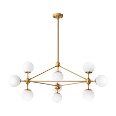 a chandelier with five white balls hanging from the ceiling and four gold fixtures