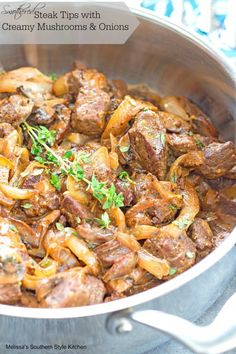 a pot filled with meat and onions on top of a stovetop oven next to a blue towel