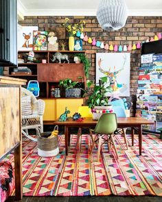 a living room filled with lots of furniture and colorful rugs on top of a wooden floor