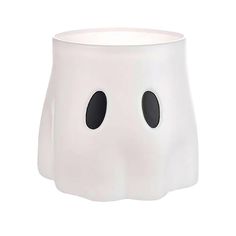 a white vase with two black eyes on the front and bottom, sitting in front of a white background