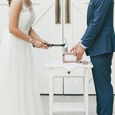 a bride and groom are cutting their wedding cake at the alter in front of an open door