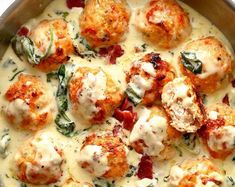 a pan filled with meatballs covered in cheese and spinach