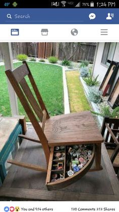 a wooden rocking chair sitting on top of a porch next to a table with buttons in it