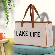 a large white bag sitting on top of a table next to a cup and plant