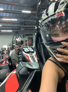 a woman with her hand on the seat of a race car in a showroom