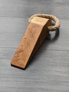 a piece of wood tied up to a rope on top of a wooden flooring board