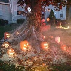 pumpkins are lit up on the ground in front of a house with halloween decorations