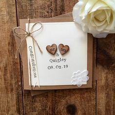 two wooden hearts are attached to a wedding card