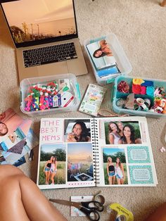 a laptop computer sitting on top of a floor next to a pile of pictures and crafting supplies