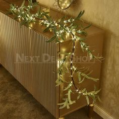 a radiator with some lights on it next to a wall and a plant