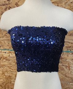 Blackbird Vintage of Sedona Arizona presents to you this sequined tube top. It is dark navy blue in color, and would look great with just about anything! Excellent vintage condition with no detectable flaws . The top does have some stretch and should fit sizes XS through M. Please check measurements in photo.  Since this is a vintage item, all sales are final. No refunds or returns. Please ask any questions before placing order. Cheap Embellished Blue Tops, Blue Bandeau Tops For Night Out, Blue Self-design Party Top, Strapless Blue Crop Top For Night Out, Blue Bandeau Tube Top For Party, Blue Strapless Crop Top For Night Out, Chic Blue Party Crop Top, Blue And Silver Outfits, Blue Cropped Crop Top For Evening