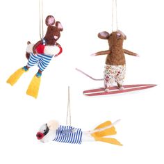 three stuffed animals hanging from strings in the shape of mouses on surfboards and surfing boards