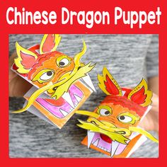 someone is holding two paper boxes with dragon faces on them and one has its mouth open