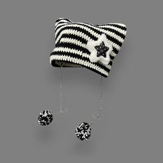 a black and white knitted hat with stars hanging from it's ear ends