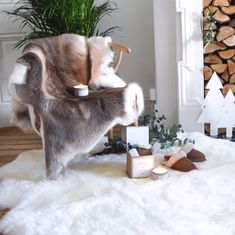 a cat sitting on top of a chair next to a pile of wood and other items