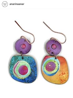 two colorful earrings are hanging from hooks on a white background with the words anannanar written