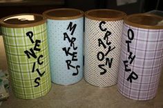 four different colored paper cups with writing on them sitting next to each other in a row