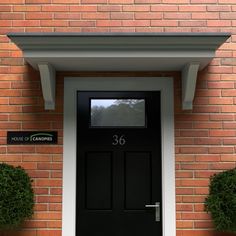 a black front door with two potted plants next to it